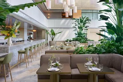 a restaurant with couches and tables and plants at AKA Hotel Stunning Views w- Free parking in Miami