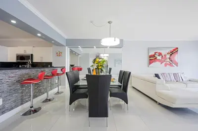 a dining room and living room with a table and chairs at Golden Bay 702 in Sunny Isles Beach