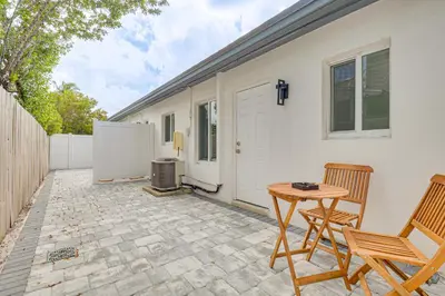 a patio with two chairs and a table and a heater at Walk to Dining and Nightlife! Chic Apt Near Las Olas in Fort Lauderdale