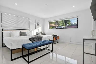 a bedroom with two beds and a table in it at Miami Private Pool Home 15 min to Beach - Aventura in Miami