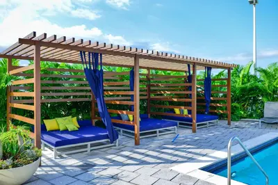 a wooden pergola next to a swimming pool at Contemporary Midtown Condo - Pool & Free Parking in Miami