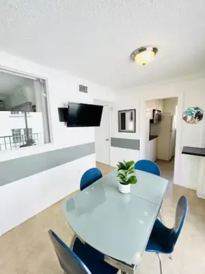 a dining room with a white table and blue chairs at The Blue Breeze - Parking included in Miami Beach