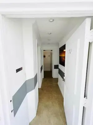 a hallway with white walls and a hallway with black and white walls at The Blue Breeze - Parking included in Miami Beach
