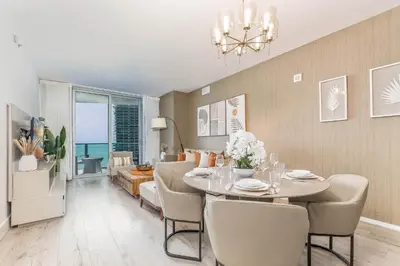 a dining room and living room with a table and chairs at Luxurious Beachfront 2-Bedroom 2-Bathroom with balcony Condo at Lyft Resort & Residences - Miami Beach in Hollywood