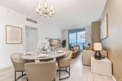 a dining room and living room with a table and chairs at Luxurious Beachfront 2-Bedroom 2-Bathroom with balcony Condo at Lyft Resort & Residences - Miami Beach in Hollywood