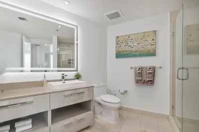 a white bathroom with a toilet and a sink at Luxurious Beachfront 2-Bedroom 2-Bathroom with balcony Condo at Lyft Resort & Residences - Miami Beach in Hollywood