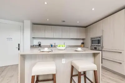 a kitchen with a counter and stools in a kitchen at Luxurious Beachfront 2-Bedroom 2-Bathroom with balcony Condo at Lyft Resort & Residences - Miami Beach in Hollywood
