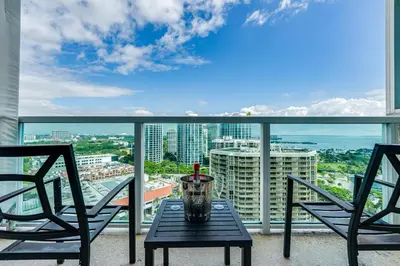 a table and two chairs on a balcony with a view at Coconut Grove Bayview Retreat 2 King Suites Pool Gym and Free Parking in Miami