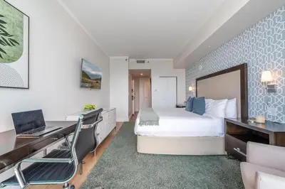 a bedroom with a bed and a desk with a laptop at Coconut Grove Bayview Retreat 2 King Suites Pool Gym and Free Parking in Miami