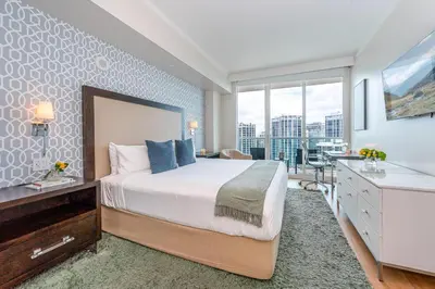 a bedroom with a bed and a desk and a window at Elevated Grove Escape with Balcony & Bay Views-Includes Parking in Miami