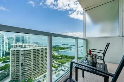 a balcony with a table and a view of a city at Grove Bayview Getaway Stunning Views Pool Access & Parking in Miami