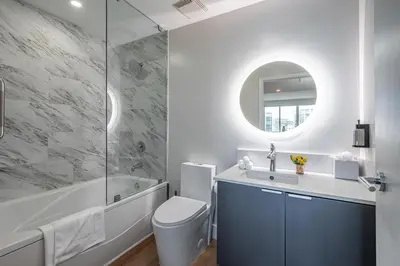 a bathroom with a toilet and a tub and a sink at Grove Bayview Getaway Stunning Views Pool Access & Parking in Miami