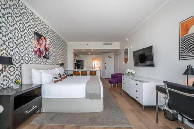 a hotel room with a bed and a television at Grove Bayview Getaway Stunning Views Pool Access & Parking in Miami
