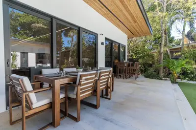 an outdoor patio with a wooden table and chairs at Luxury Miami Oasis with Heated Pool and BBQ Grill in Miami