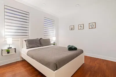 a white bedroom with a bed and two windows at Luxury 5BR Villa Private Pool I Jacuzzi I BBQ I Piano I Near Miami Airport in Kendale Lakes