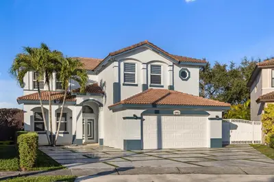 a white house with a palm tree and a driveway at Luxury 5BR Villa Private Pool I Jacuzzi I BBQ I Piano I Near Miami Airport in Kendale Lakes