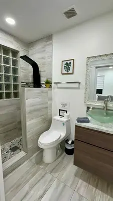 a bathroom with a toilet and a sink at Luxury 5BR Villa Private Pool I Jacuzzi I BBQ I Piano I Near Miami Airport in Kendale Lakes