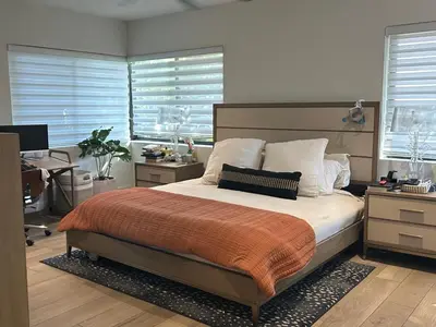 a bedroom with a bed and a desk and windows at Luxury Miami home with heated pool & BBQ area, close to beaches & sports arenas in Miami