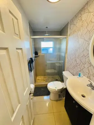 a bathroom with a shower and a toilet and a sink at Modern Boho 3BR Duplex Escape with Pool & King Bed Near Beach in Fort Lauderdale
