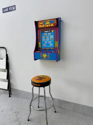 a stool in front of a video game machine at Oasis Yard -Pool-Jets-Game Room-BBQ-Relaxing in Carver Ranches