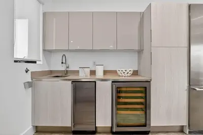 a kitchen with white cabinets and stainless steel appliances at Shoreline Villa by Rove - Rooftop & Beach Access in Hollywood