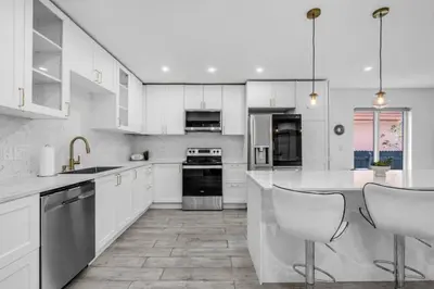 a white kitchen with white cabinets and appliances at Contemporary Family Oasis Pool and Comfort in Miami