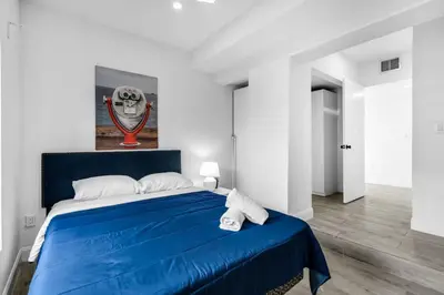 a bedroom with a blue bed in a white room at Contemporary Family Oasis Pool and Comfort in Miami