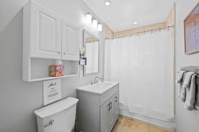 a white bathroom with a toilet and a sink at 2 bed, steps from Wilton Drive, BBQ, fire pit in Fort Lauderdale