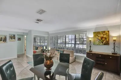 a living room with a table and chairs and a couch at Waterfront, Heated Pool, Game Room in Fort Lauderdale