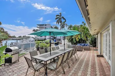 a table and chairs with an umbrella on a patio at Waterfront, Heated Pool, Game Room in Fort Lauderdale