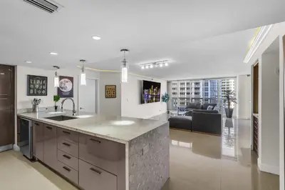a kitchen with a sink and a living room at Seaview Work Haven Condo for 6 in Miami