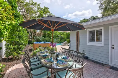 a table and chairs with an umbrella on a patio at Beach Oasis Heated Pool, Gazebo, Hot Tub in Fort Lauderdale