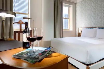 a bedroom with a bed and two glasses of wine at Eurostars Langford in Miami