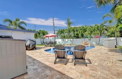 a patio with a table and chairs and a pool at Aquaria in Fort Lauderdale