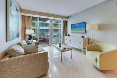 a living room with a couch and a tv at Oceanfront Retreat- South Beach Pool Amenities in Miami Beach