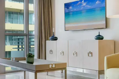 a living room with a tv on the wall at Oceanfront Retreat- South Beach Pool Amenities in Miami Beach