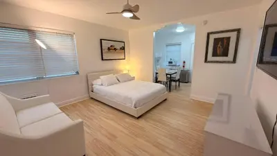a bedroom with a bed and a chair and a table at Cozy 1BR Beach Apartment Walk to Miami Beach in Miami Beach