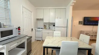 a kitchen with white cabinets and a table with a microwave at Cozy 1BR Beach Apartment Walk to Miami Beach in Miami Beach