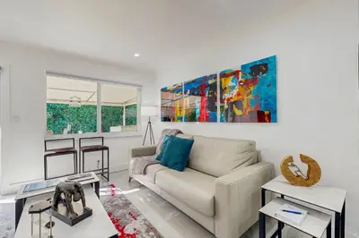 a living room with a couch and a painting on the wall at JS & JS 2040 LLC in Fort Lauderdale