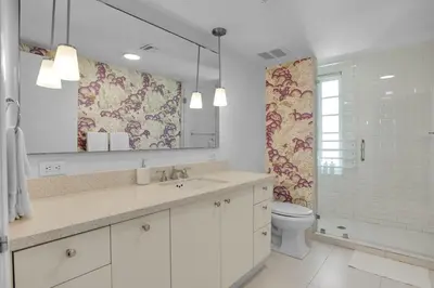 a bathroom with a sink and a toilet and a mirror at Peaceful 2BR Condo with Ocean Views on Ocean Drive South Beach in Miami Beach