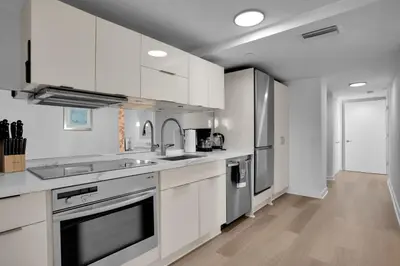 a kitchen with white cabinets and stainless steel appliances at Peaceful 2BR Condo with Ocean Views on Ocean Drive South Beach in Miami Beach