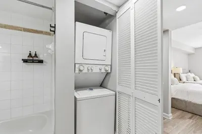 a white bathroom with a shower and a bed at Stylish Brickell Stay with Ocean Views & Pool in Miami