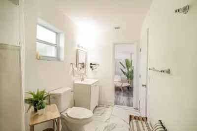a white bathroom with a toilet and a sink at Suite Mar - Unit B in Miami
