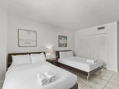 a bedroom with two beds with towels on them at Sea Air Towers - Oceanfront Condo w Pool & Gym in Hollywood