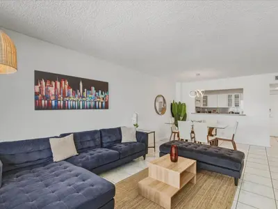 a living room with a blue couch and a table at Sea Air Towers - Oceanfront Condo w Pool & Gym in Hollywood