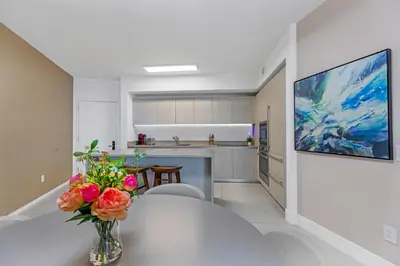 a kitchen with a table with a vase of flowers on it at Lyfe Resort l Ocean Pool View Gym, Beach Access in Hollywood