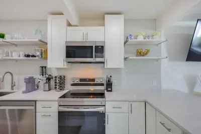 a kitchen with white cabinets and a stove top oven at Couples Retreat 1 Mi to Fort Lauderdale Riverwalk in Fort Lauderdale