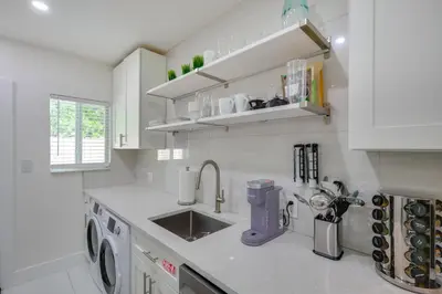a white kitchen with a sink and a dishwasher at Couples Retreat 1 Mi to Fort Lauderdale Riverwalk in Fort Lauderdale