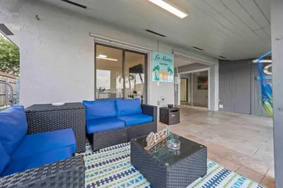 a patio with blue couches and a table at Serene Lakefront Getaway Fishing & Kayaks in Fort Lauderdale