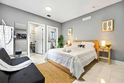 a bedroom with a large bed and a chair at Modern Studio in Wynwood Midtown in Miami